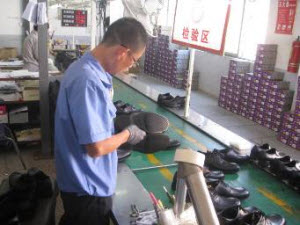 A worker inspects leather shoes in a Chinese factory