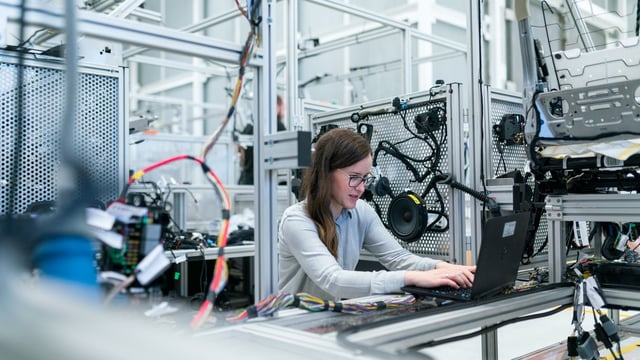 A skilled engineer performing quality control in an electronics manufacturing plant