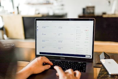 A close-up of a person going through business analytics on a laptop.