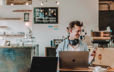 A smiling man using a smartphone.
