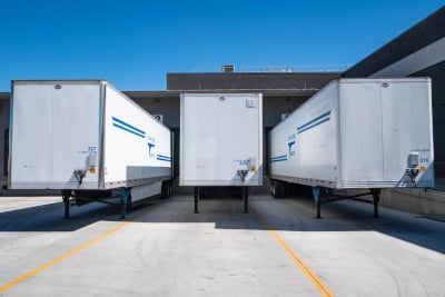 Three white enclosed trailers.