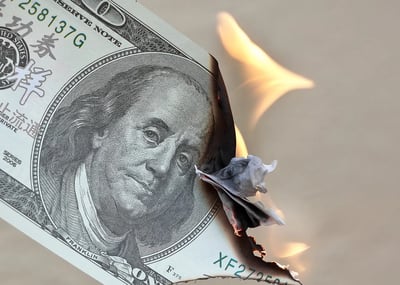 A close-up of a dollar bill on fire.