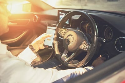 A man turning on his car with a phone.