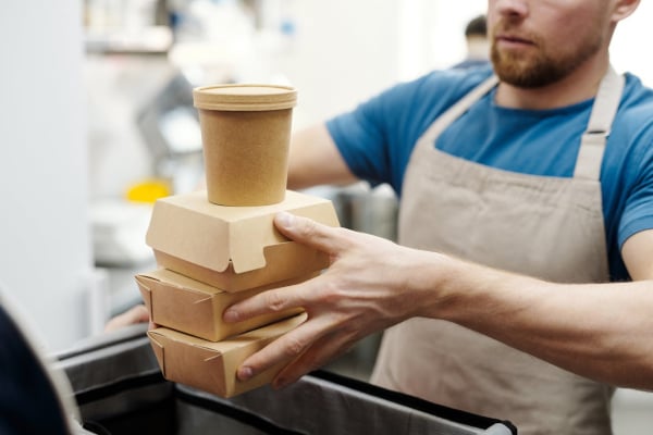 Man placing cardboard-packaged items into a box