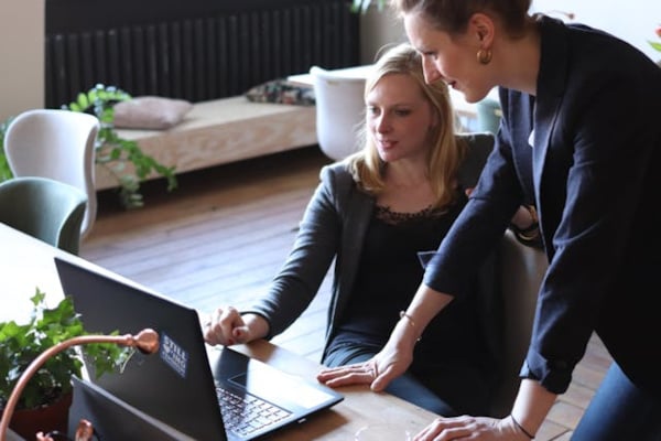 Two women looking at a laptop.