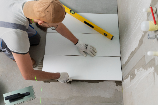 Man  paving tiles in his house
