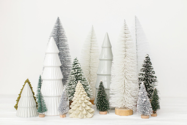 Many tabletop Christmas tree decorations on a table