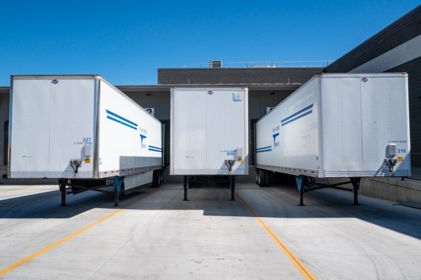 Three white enclosed trailers