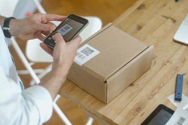 a person scanning a QR code on a delivery box