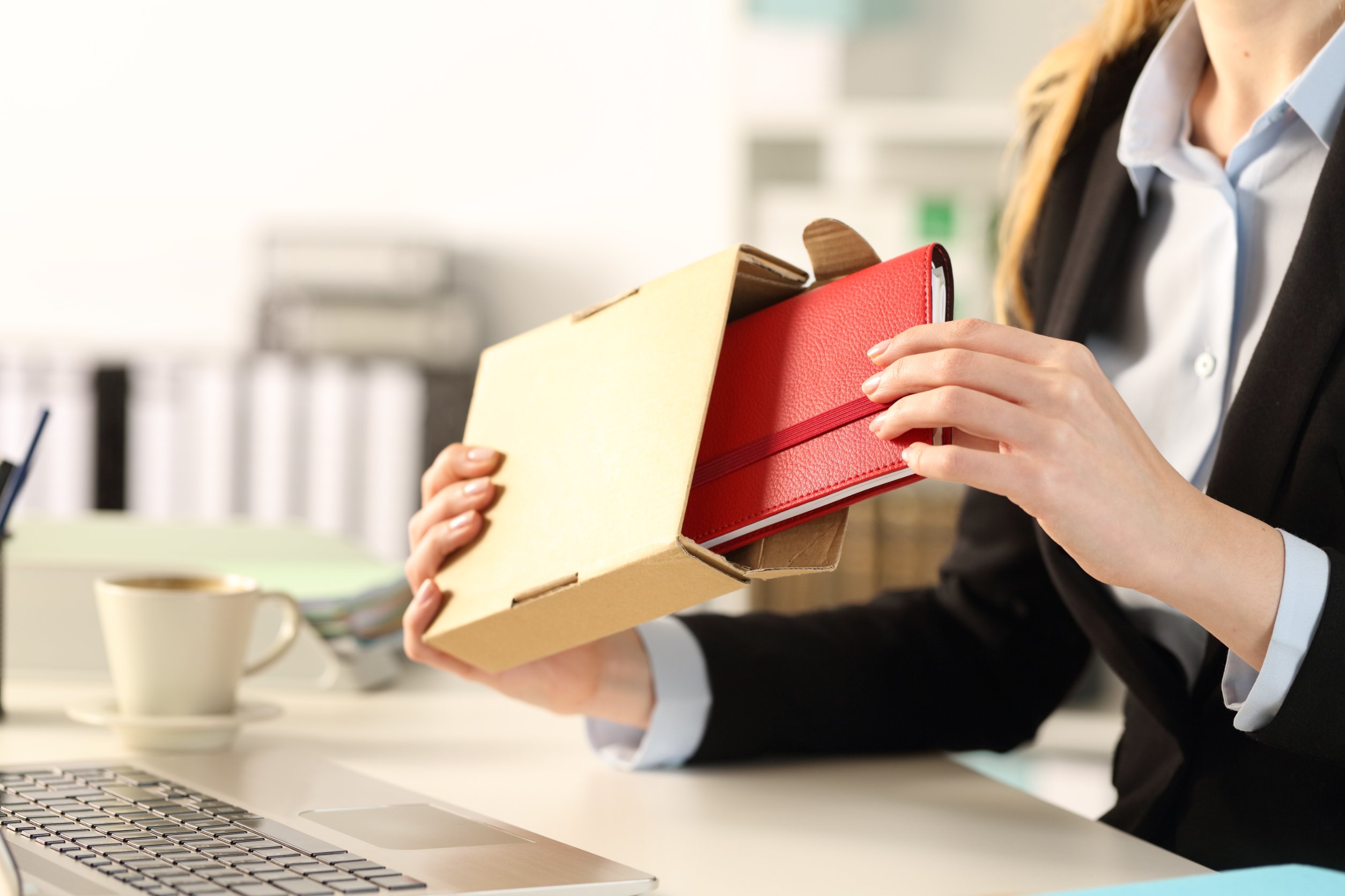 woman opening a gift from her company