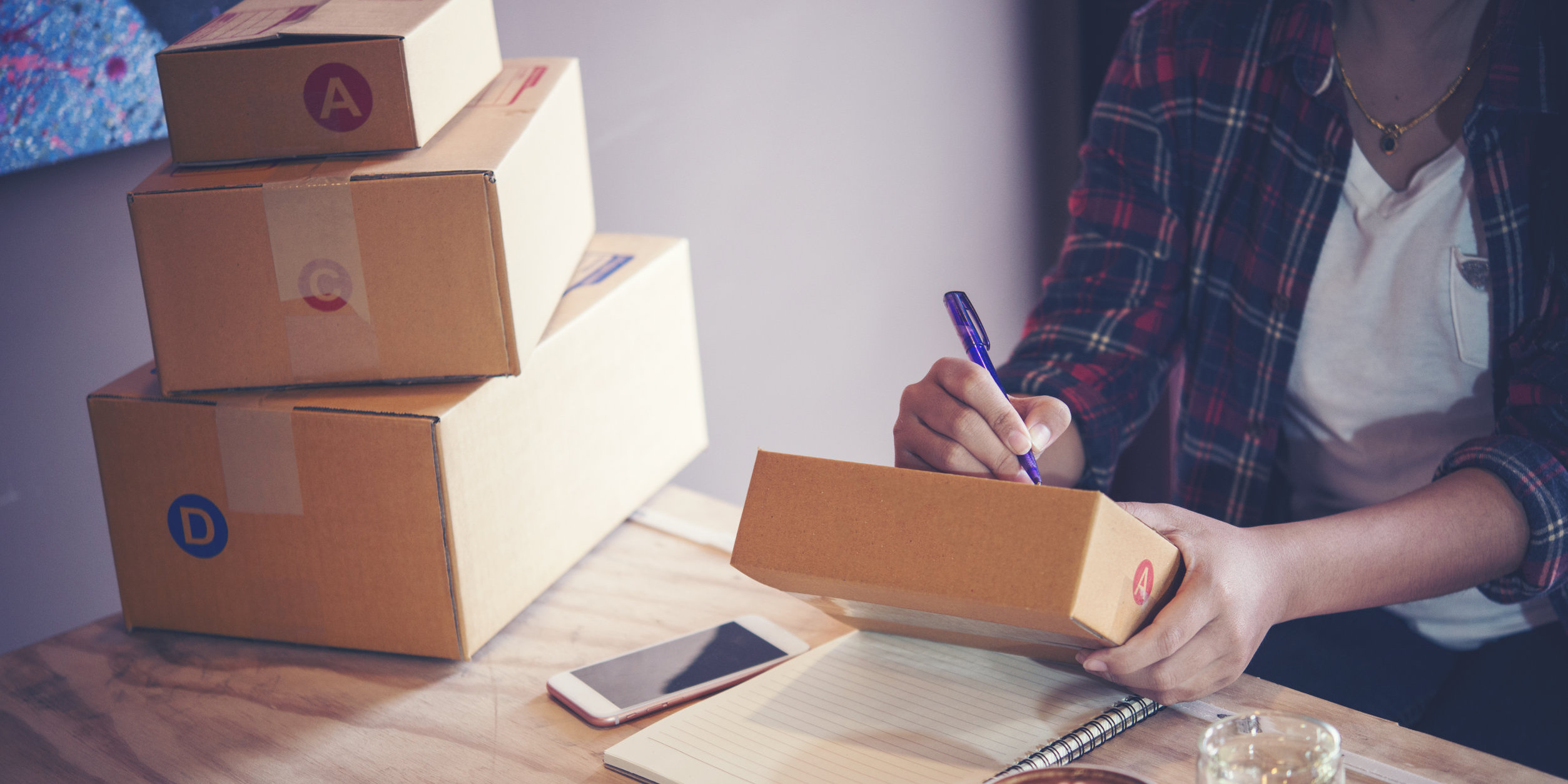 Amazon FBA seller writing on a package she is shipping to her customers while working from home