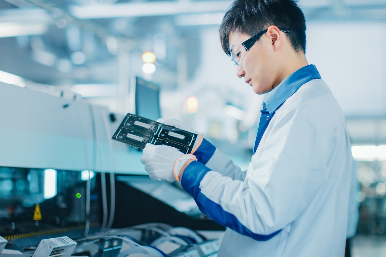 Quality Control Engineer Checks Electronic Printed Circuit Board for Damages