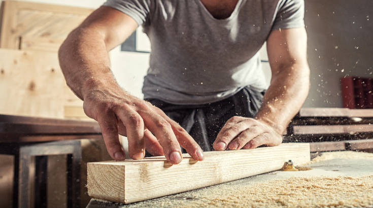  A man doing carpentry with a wood block